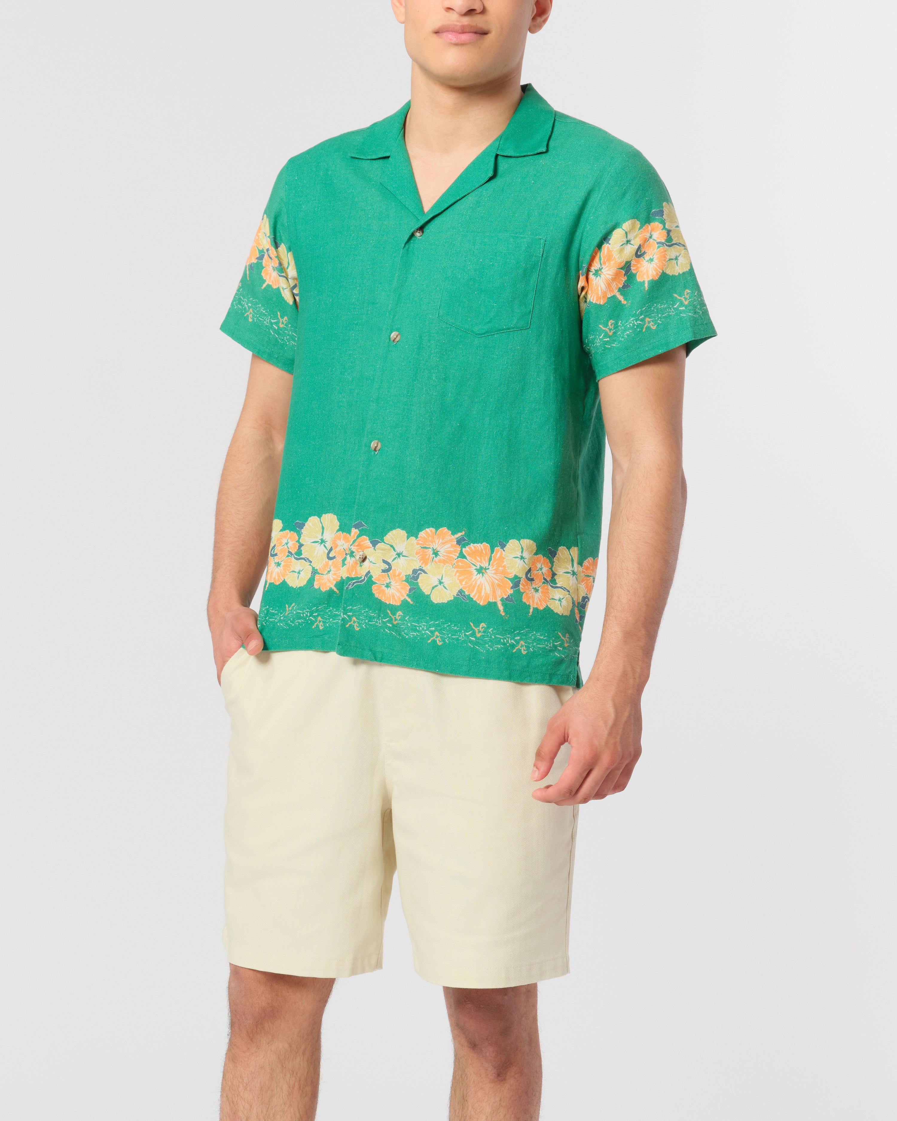 Green camp shirt with floral motif pattern on the sleeves and bottom hem Shot on Model