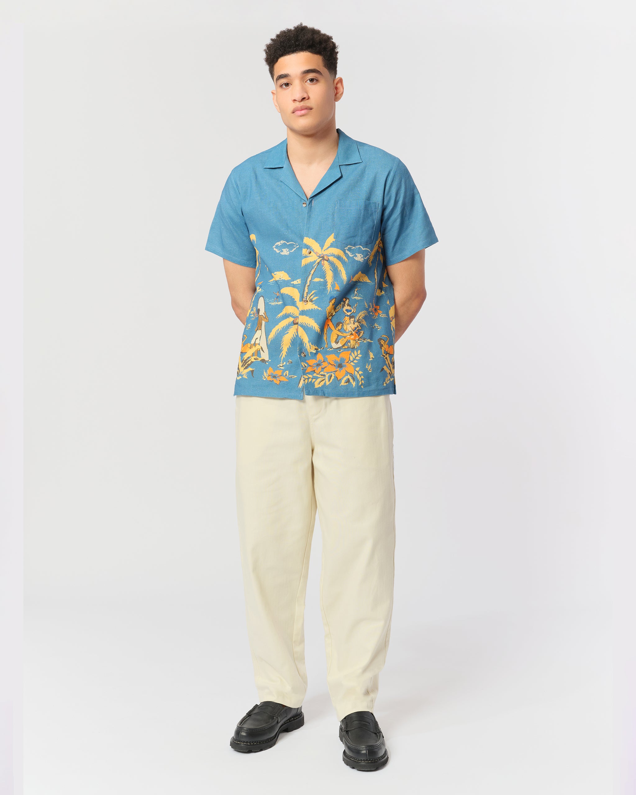Blue linen Hawaiian-inspired beach scene camp collar shirt shot on model
