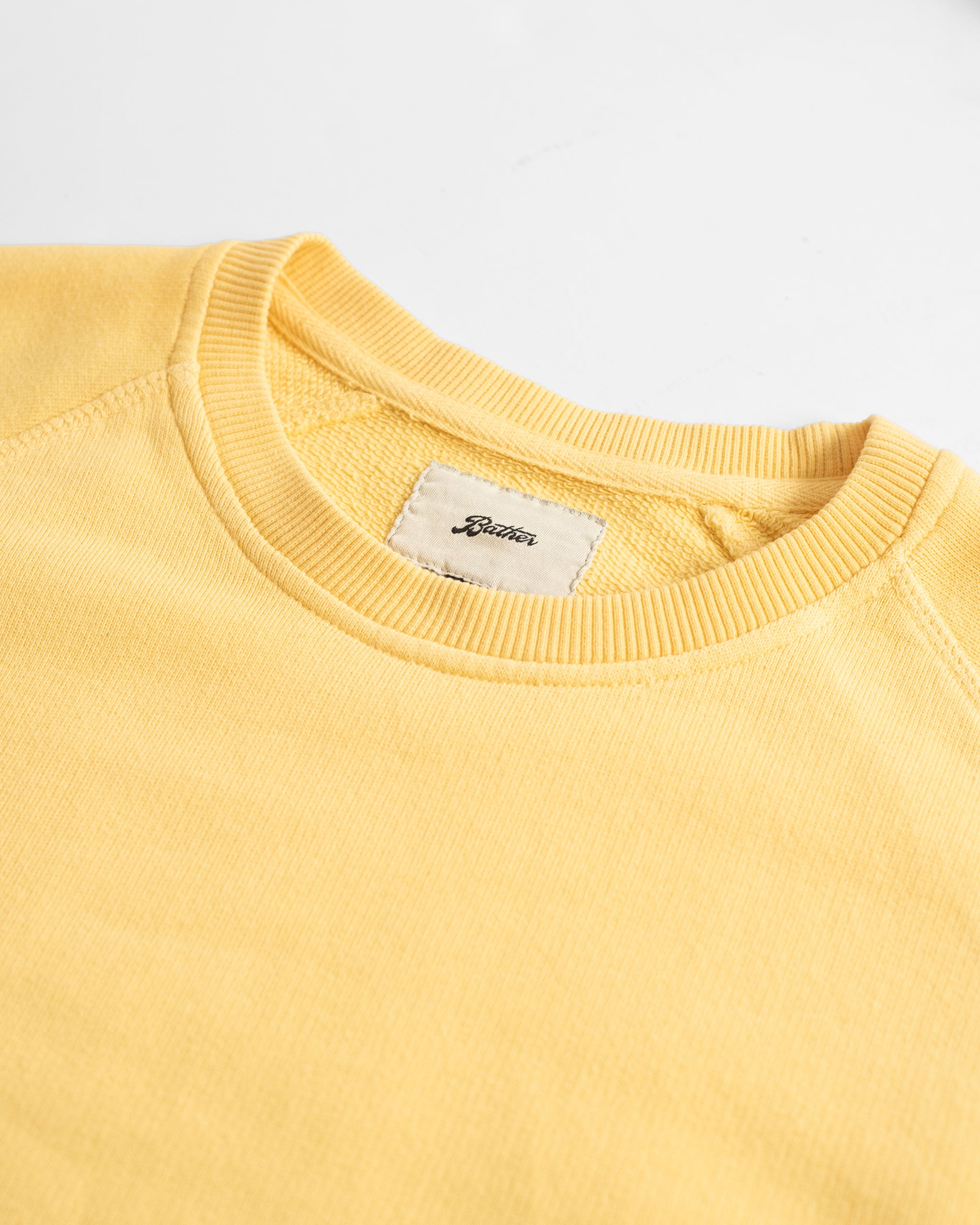 Collar close up shot of Canary yellow french terry raglan sleeve crewneck sweatshirt