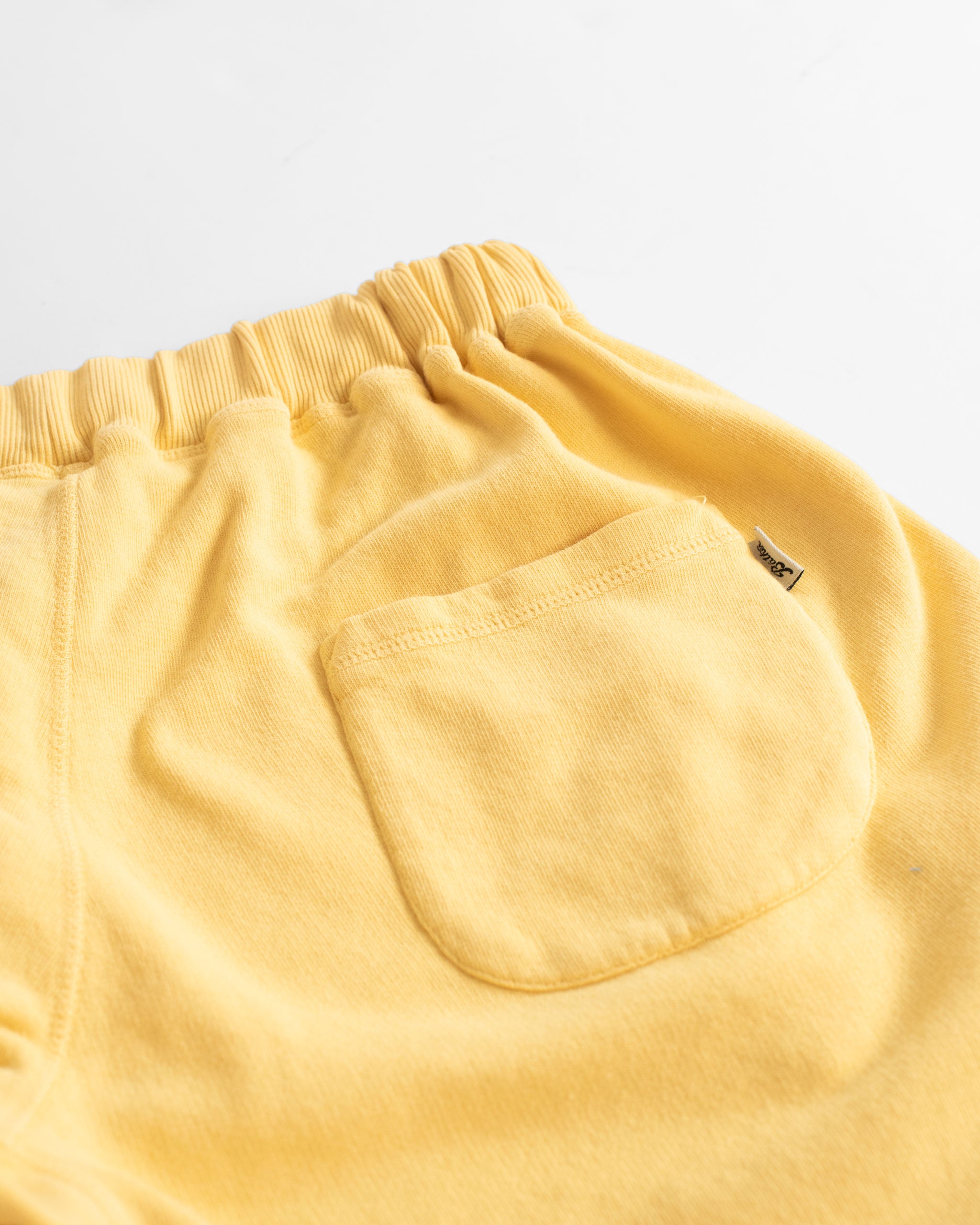 Back pocket close up of Canary yellow french terry sweat shorts