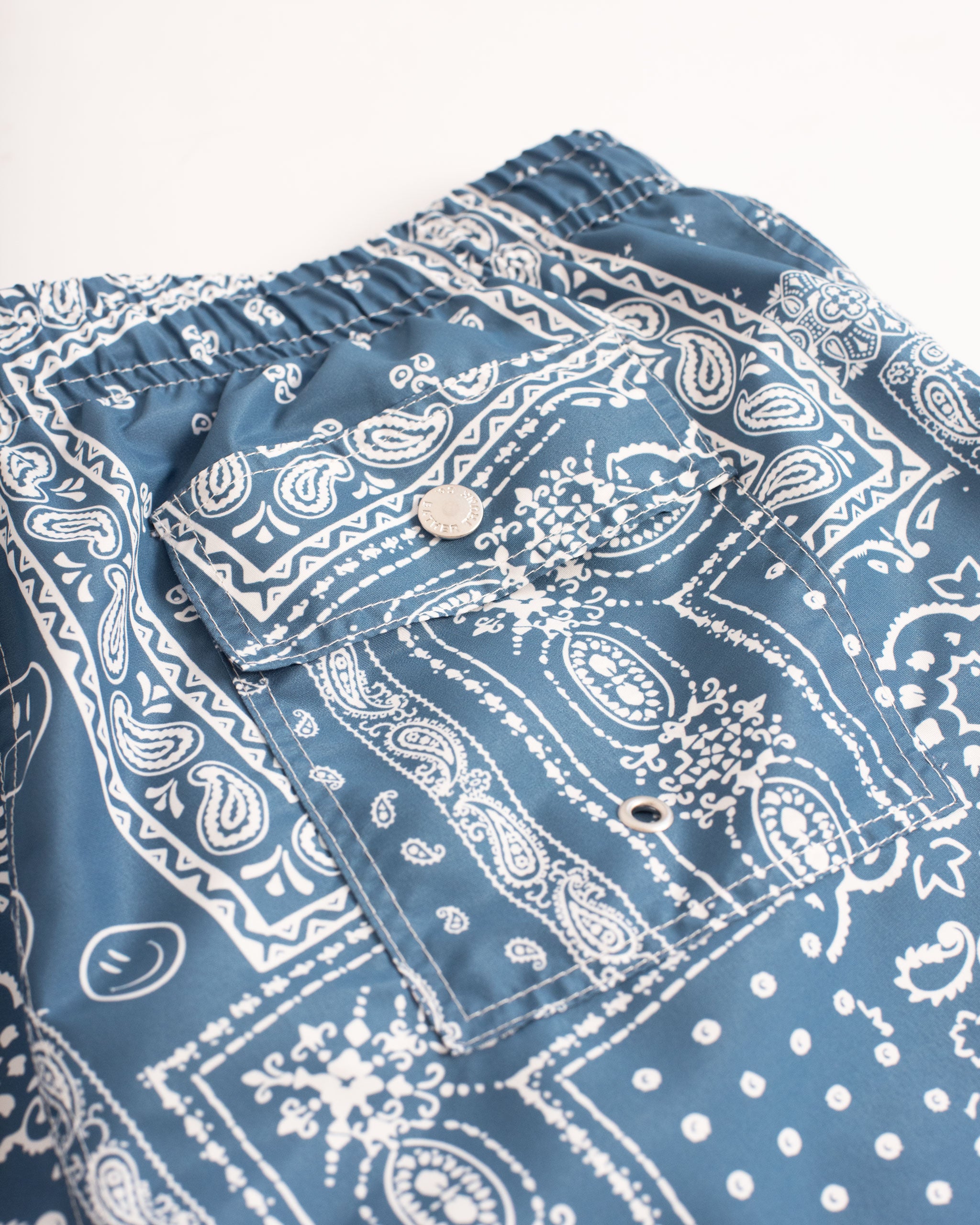 Back Pocket Shot Of Blue swim trunk with all-over bandana print