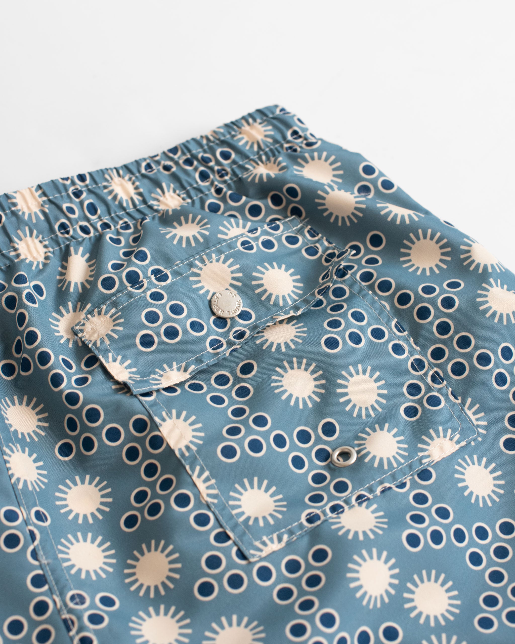 back pocket close up of Steel blue disco sun motif all over print swim trunks