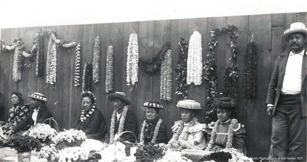 Lei vendors seated at the pier selling leis.