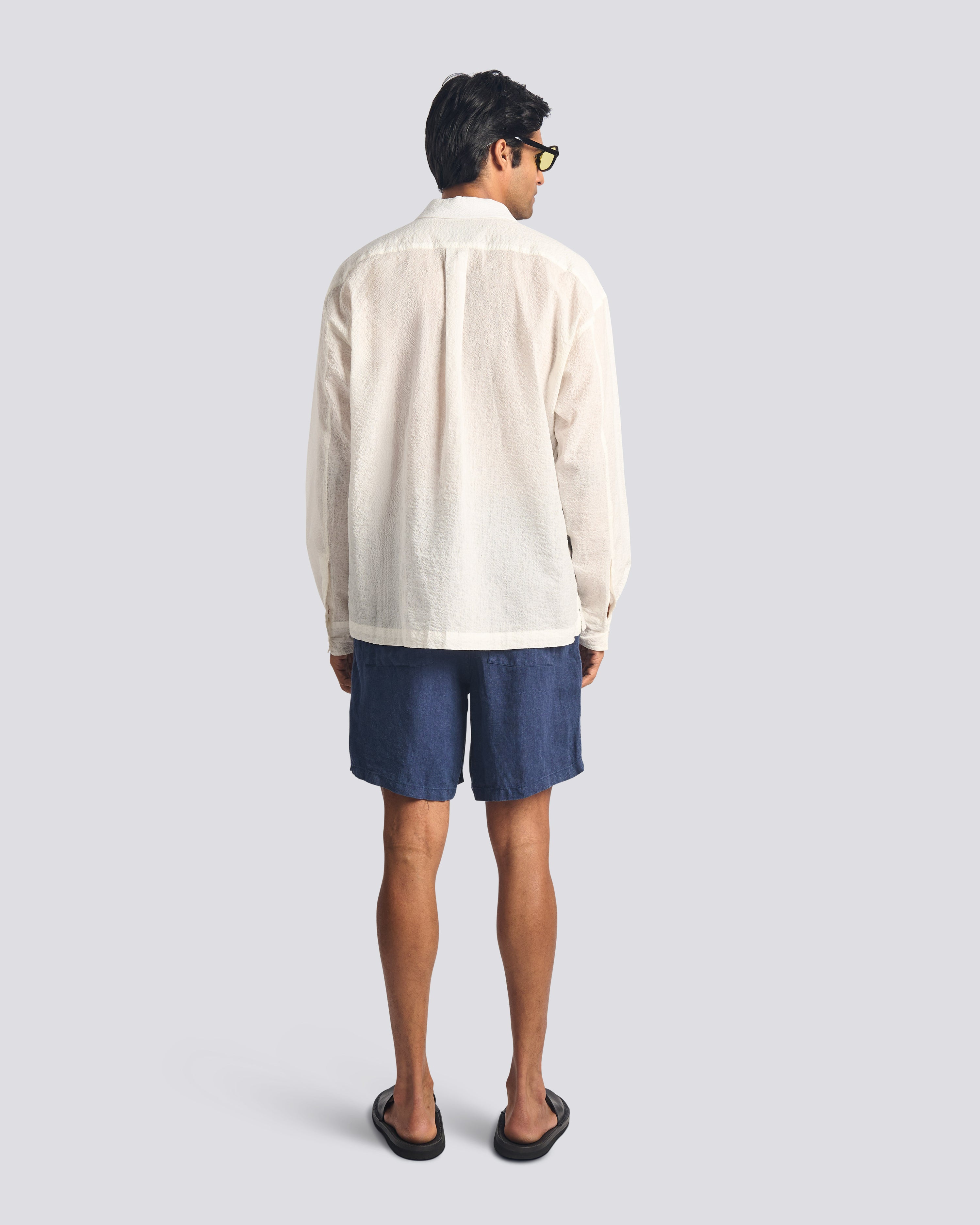 Back view of model wearing Bather men's navy linen leisure shorts