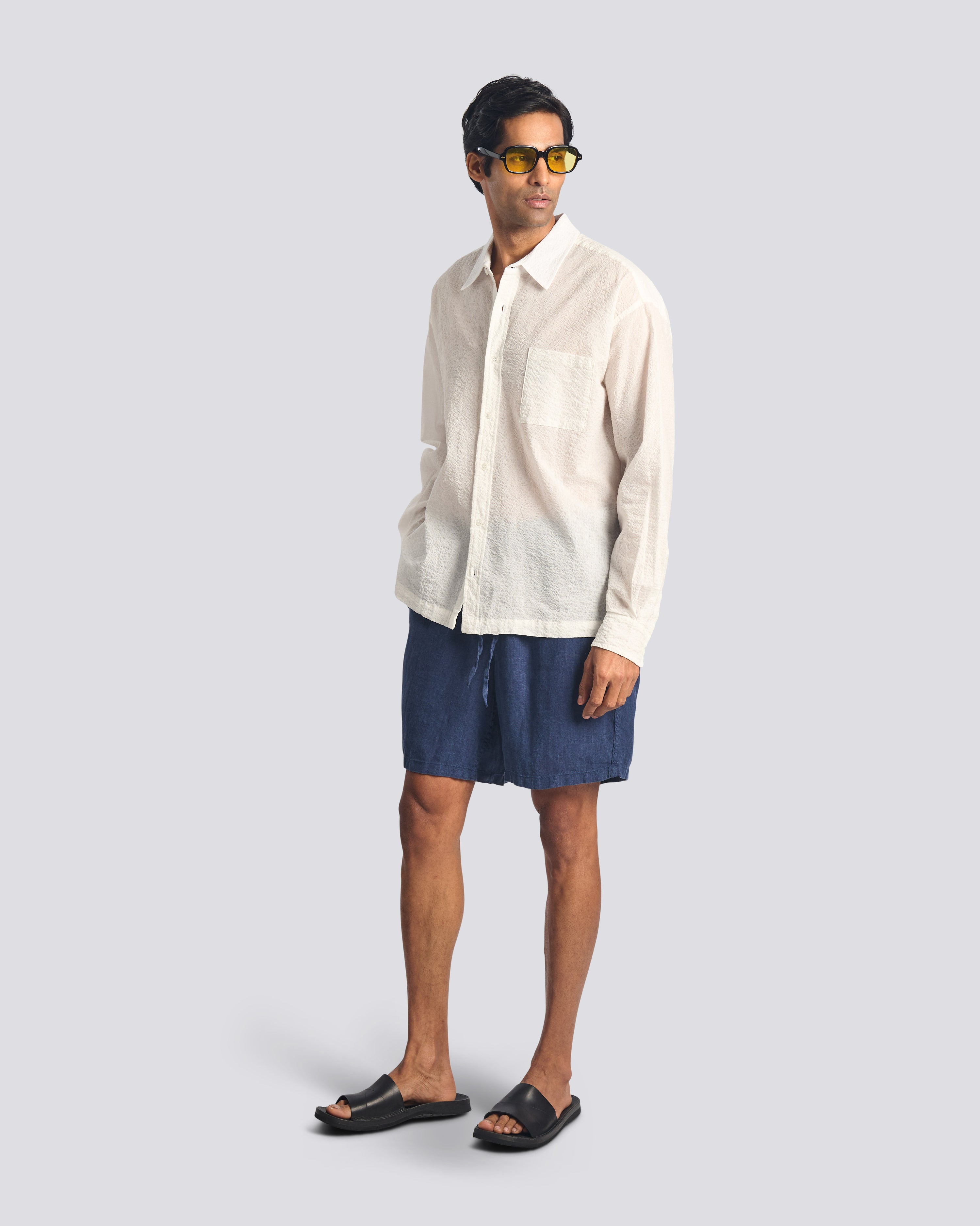 Model wearing Bather men's navy linen drawstring shorts on white background