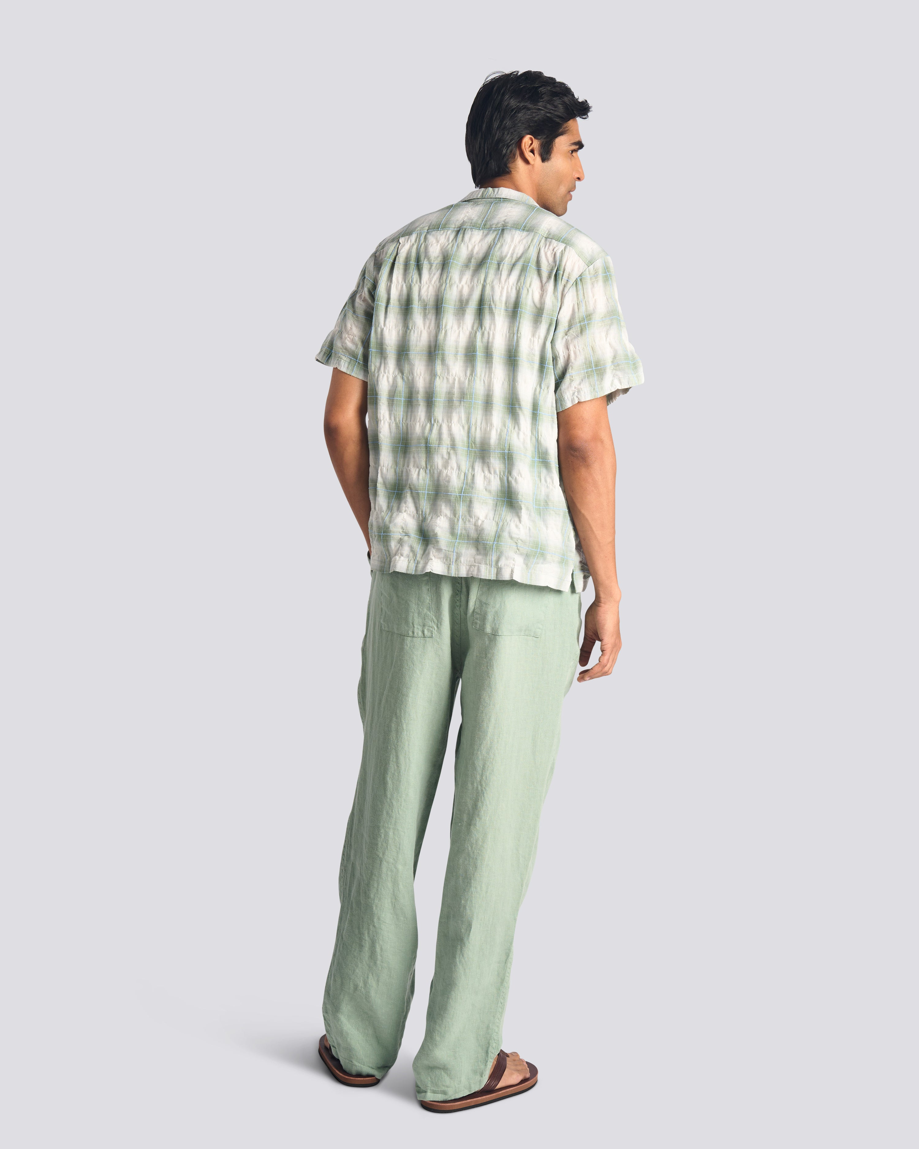 Back view of model wearing Bather men's light green linen drawstring pants
