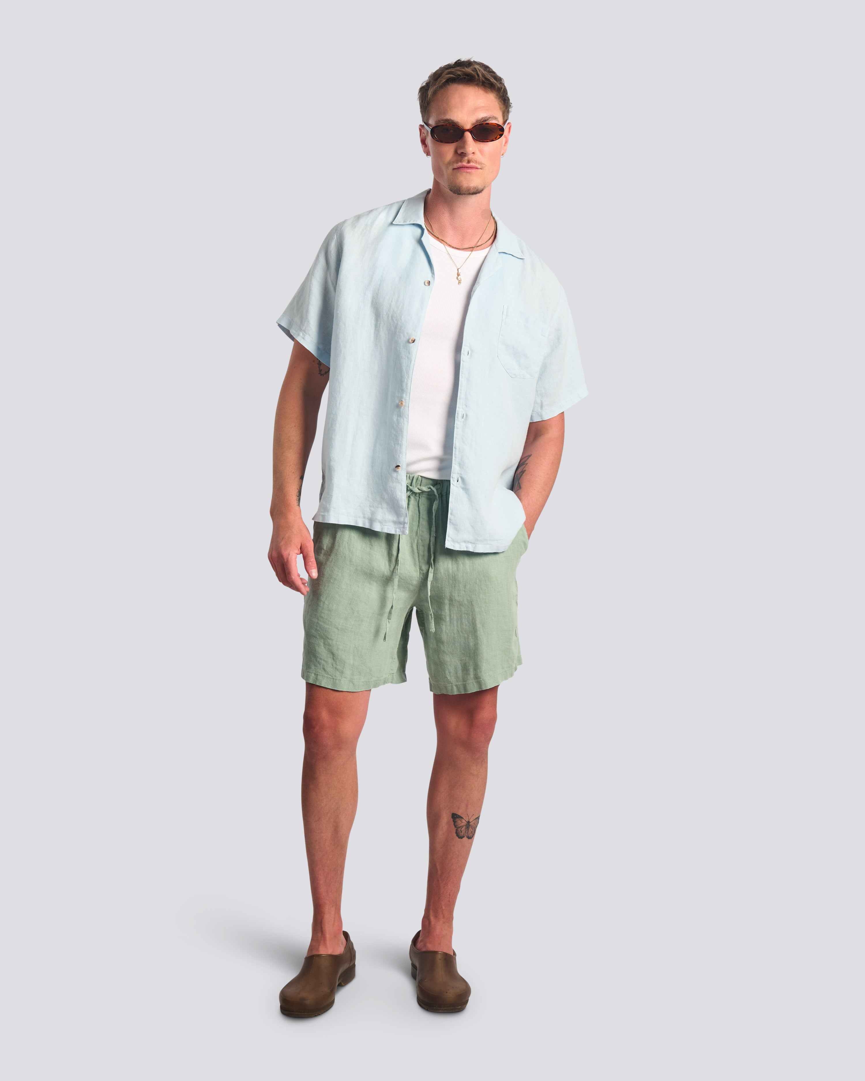 Model wearing Bather men's light green linen drawstring shorts.