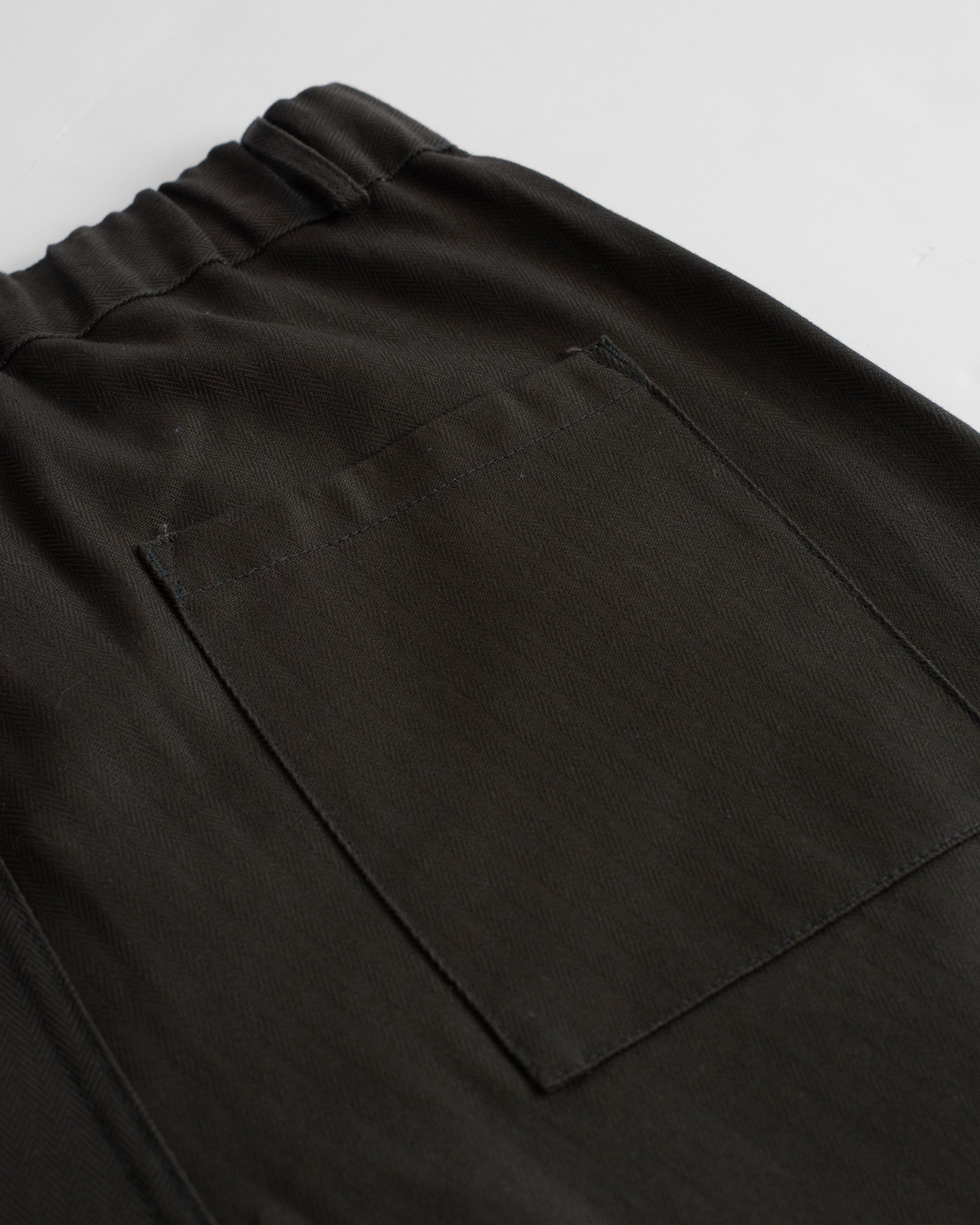 Closeup back pocket of Bather dark green herringbone leisure shorts