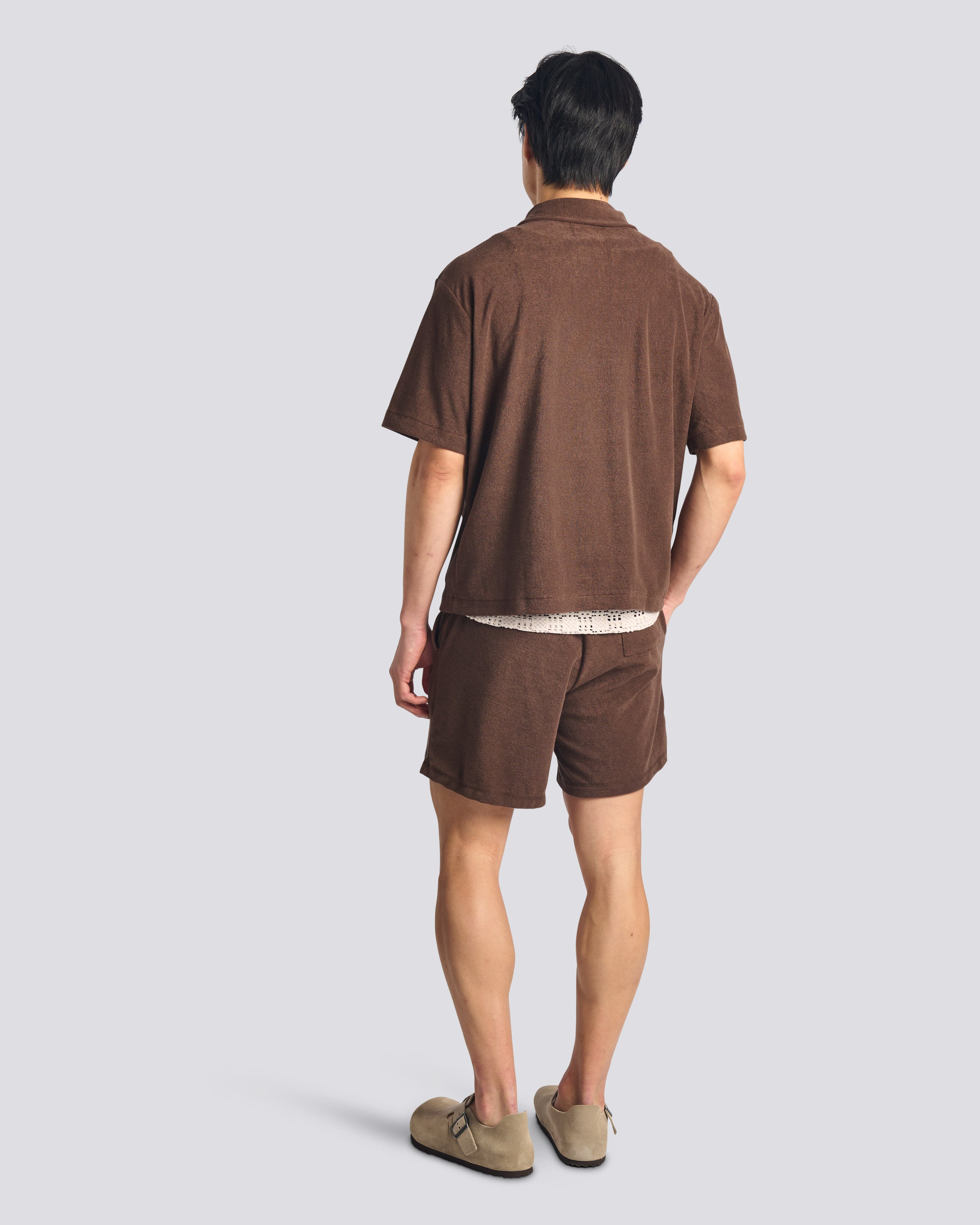 Back view of model wearing Bather men's dark brown towel terry shorts