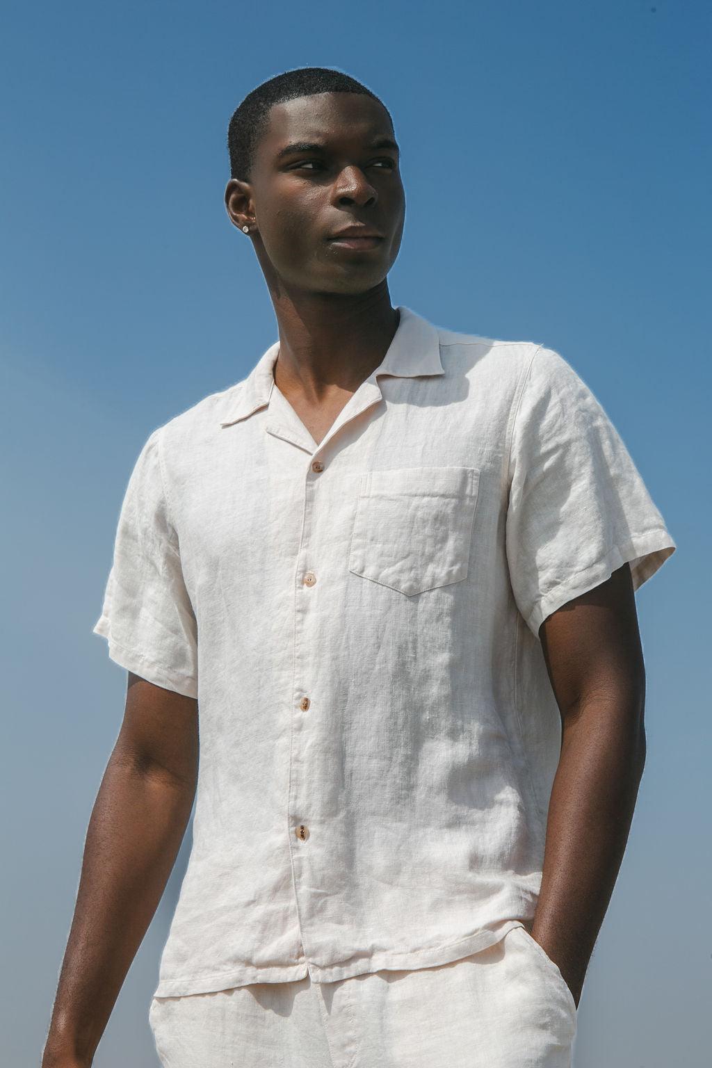 Portrait of a man wearing a White Linen Camp shirt looking out in the distance