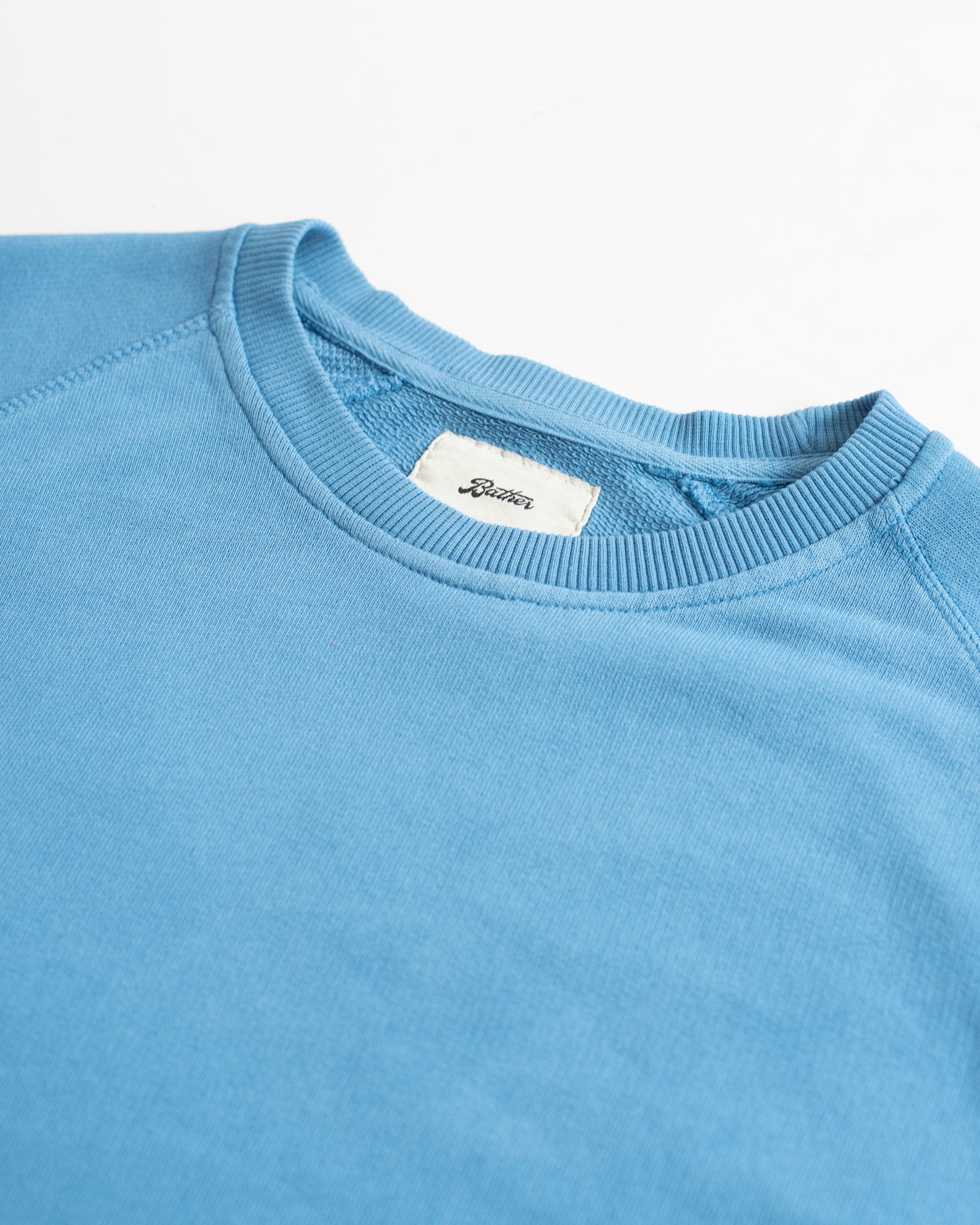 Collar close up of Solid Blue French Terry Cotton Raglan Sleeve Crewneck Sweatshirt